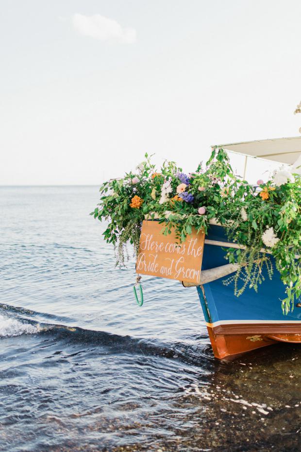 Bride and groom  arrive on a decorated with flowers boat 