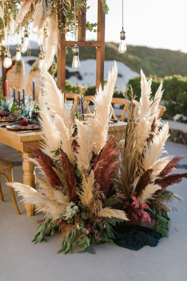 Pampas grass and Edison lamps wedding dinner set up